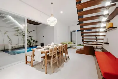 a dining room with a table and chairs and a pool at Casa De Vero Amore in Jimbaran