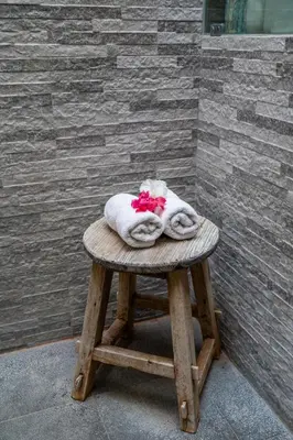 a pile of towels sitting on top of a wooden stool at Tropical 2BR Villa with Private Pool in Canggu in Canggu