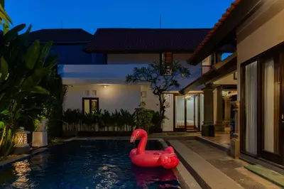 a pool with a red swan in the middle of a house at Purnava Village by Behomy in Ngurah Rai International Airport