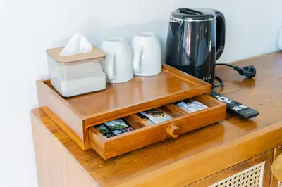 a wooden counter top with a coffee maker on it at Purnava Village by Behomy in Ngurah Rai International Airport