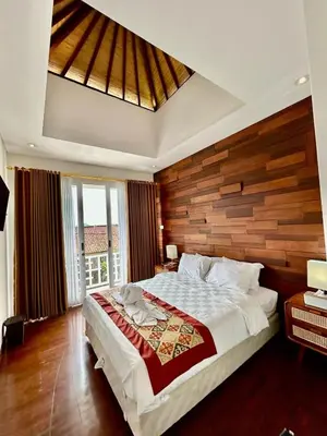 a bedroom with a large bed with a wooden wall at Villa Velia 3BR private pool in Badung