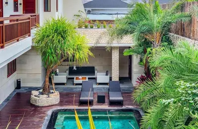 a courtyard with a swimming pool and palm trees at Elf Belly 4 BR Canggu Heart Vila CYN in Canggu