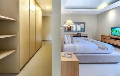 a bedroom with a large bed and a tv at Elf Belly 4 BR Canggu Heart Vila CYN in Canggu