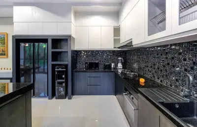 a kitchen with white cabinets and black tiles at Elf Belly 4 BR Canggu Heart Vila CYN in Canggu