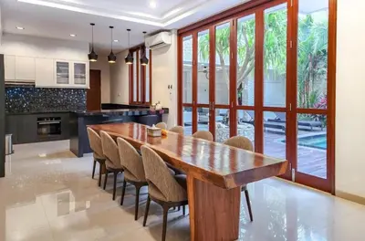 a large dining room with a wooden table and chairs at Elf Belly 4 BR Canggu Heart Vila CYN in Canggu
