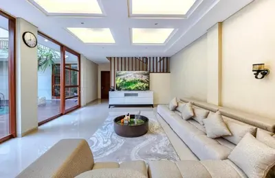 a living room with a couch and a tv at Elf Belly 4 BR Canggu Heart Vila CYN in Canggu