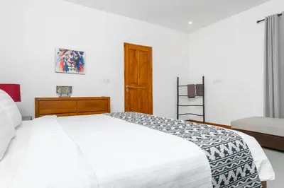 a white bedroom with a white bed and a window at Villa Damai Canggu in Seminyak
