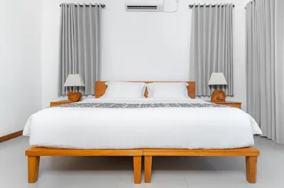 a bedroom with a white bed and two lamps at Villa Damai Canggu in Seminyak