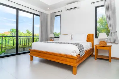 a bedroom with a bed and large windows at Villa Damai Canggu in Seminyak