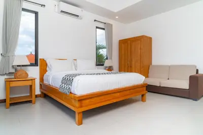 a bedroom with a bed and a couch at Villa Damai Canggu in Seminyak