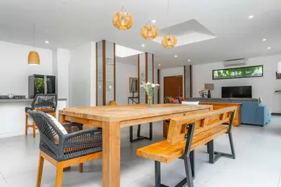 a dining room with a wooden table and chairs at Villa Damai Canggu in Seminyak