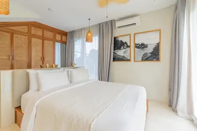 a bedroom with a white bed and a window at Villa Viento Tropical Haven Canggu in Canggu