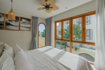 a bedroom with a bed and a large window at Villa Viento Tropical Haven Canggu in Canggu