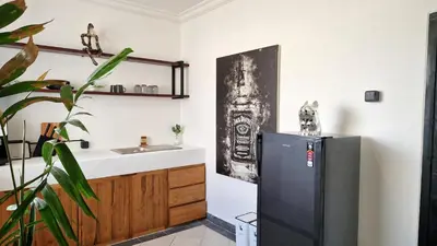 a kitchen with a black refrigerator and a sink at Nice Place To Stay - Rooftop Apartments in Seminyak
