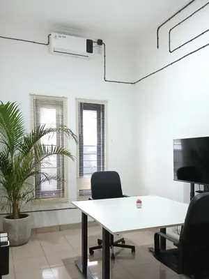 an office with a white table and two chairs and a plant at Nice Place To Stay - Rooftop Apartments in Seminyak