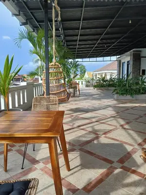 a patio with a wooden table and chairs at Nice Place To Stay - Rooftop Apartments in Seminyak