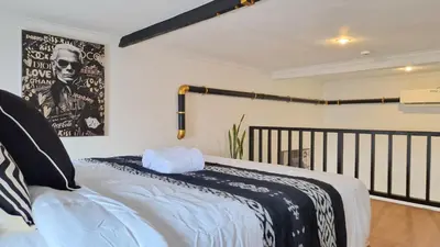 a bedroom with a bed with a black and white blanket at Nice Place To Stay - Rooftop Apartments in Seminyak