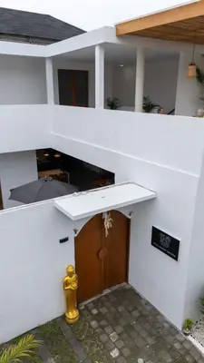 a white building with a wooden door in front at Villa Sunset Waters in Legian