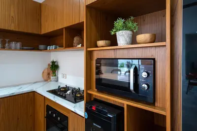 a kitchen with a microwave in a wooden cabinet at Villa Sunset Waters in Legian