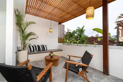 a living room with two chairs and a table at Villa Sunset Waters in Legian