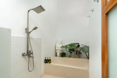 a bathroom with a shower with a shower head at Villa Sunset Waters in Legian