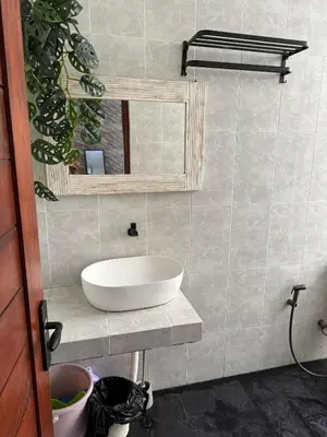 a bathroom with a white sink and a mirror at Erindra Villa in Pesanggaran