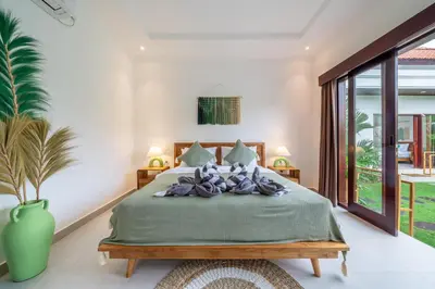a bedroom with a large bed with a green blanket at Nooky 4 - Villa with Spectacular Views in Kerobokan