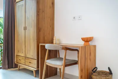a wooden desk with a chair next to a cabinet at Nooky 4 - Villa with Spectacular Views in Kerobokan