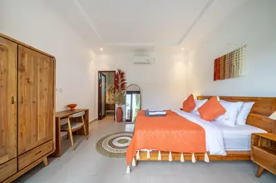 a bedroom with a bed with an orange blanket at Nooky 4 - Villa with Spectacular Views in Kerobokan