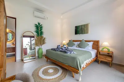 a bedroom with a large bed and a mirror at Nooky 4 - Villa with Spectacular Views in Kerobokan