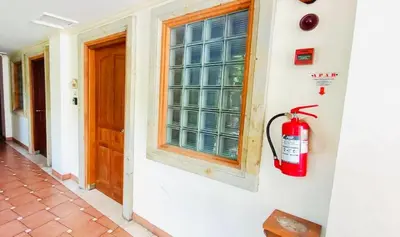 a fire extinguisher on a wall next to a window at The Palmana Tropical Roofline Jayakarta Residence 40 in Badung