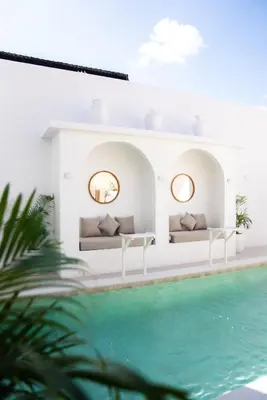 a villa with a pool in front of a house at Antana Hotel in Canggu