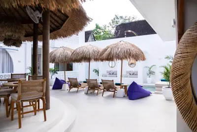 a patio with chairs and tables and umbrellas at Antana Hotel in Canggu