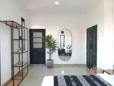 a bedroom with a bed and a mirror at Nice Place To Stay - Cozy Living in Seminyak
