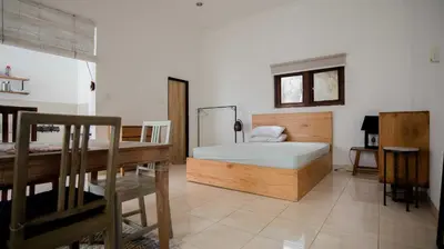 a bedroom with a bed and a desk in it at Mirri House Kerobokan in Seminyak