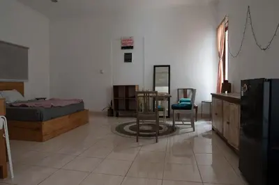 a bedroom with a bed and a table and chairs at Mirri House Kerobokan in Seminyak