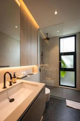 a bathroom with a sink and a toilet and a mirror at Marvee Suites Bali in Canggu
