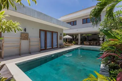 a swimming pool in front of a house at Villa Jazz 3BR 10m Pool seminyak in Seminyak