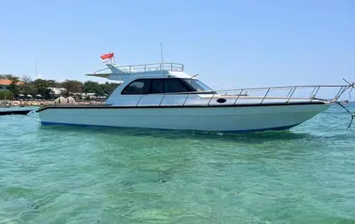 a boat sitting in the water near a beach at Круиз на Яхте с Бали на Нуса Пенида in Sanur