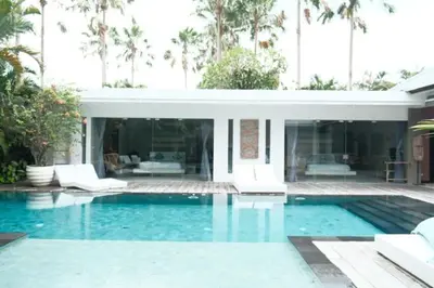 a swimming pool in front of a house at Bali paradise Rosa in Seminyak