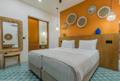 a bedroom with a large bed with an orange wall at Villa Jinjah Soul Luxury 5BR Villa,18m Pool & Garden in Seminyak