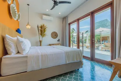 a bedroom with a bed and a view of a patio at Villa Jinjah Soul Luxury 5BR Villa,18m Pool & Garden in Seminyak