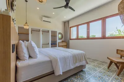 a bedroom with a large white bed and a window at Villa Pop Cozy 2BR Villa & Pool Seminyak in Seminyak