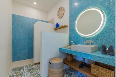 a blue bathroom with a sink and a mirror at Villa Pop Cozy 2BR Villa & Pool Seminyak in Seminyak