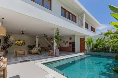 a villa with a swimming pool and a house at Villa Pop Cozy 2BR Villa & Pool Seminyak in Seminyak