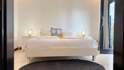 a bedroom with a white bed with two lamps on it at Villa Mandari in Seminyak