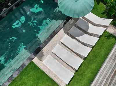 an overhead view of chairs and an umbrella next to a swimming pool at Villa Bali Manis by The Bali Agent - Central Seminyak 4BR Villa with Private Pool, Perfect for Families & Groups in Seminyak