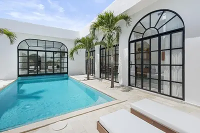 a swimming pool in the middle of a house at Chic All-White Villa with Pool and Fire Pit in Jimbaran