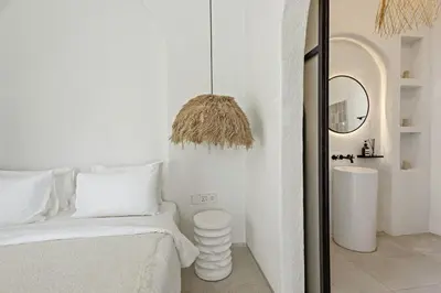 a white bedroom with a bed and a mirror at Chic All-White Villa with Pool and Fire Pit in Jimbaran