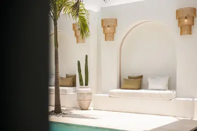 a living room with a couch and a palm tree at Chic All-White Villa with Pool and Fire Pit in Jimbaran